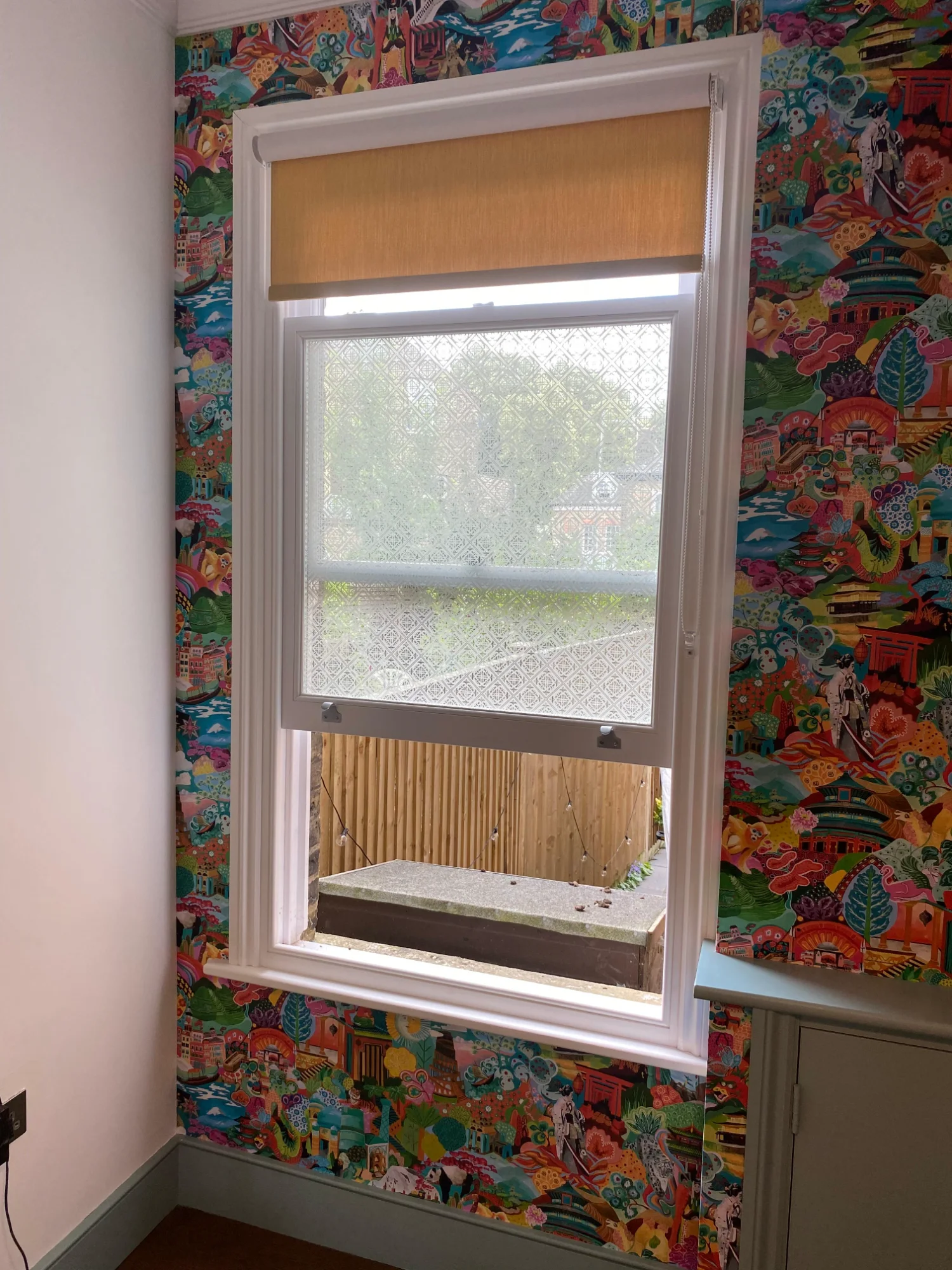 Wallpaper wrapped around architectural column with yellow trim accent