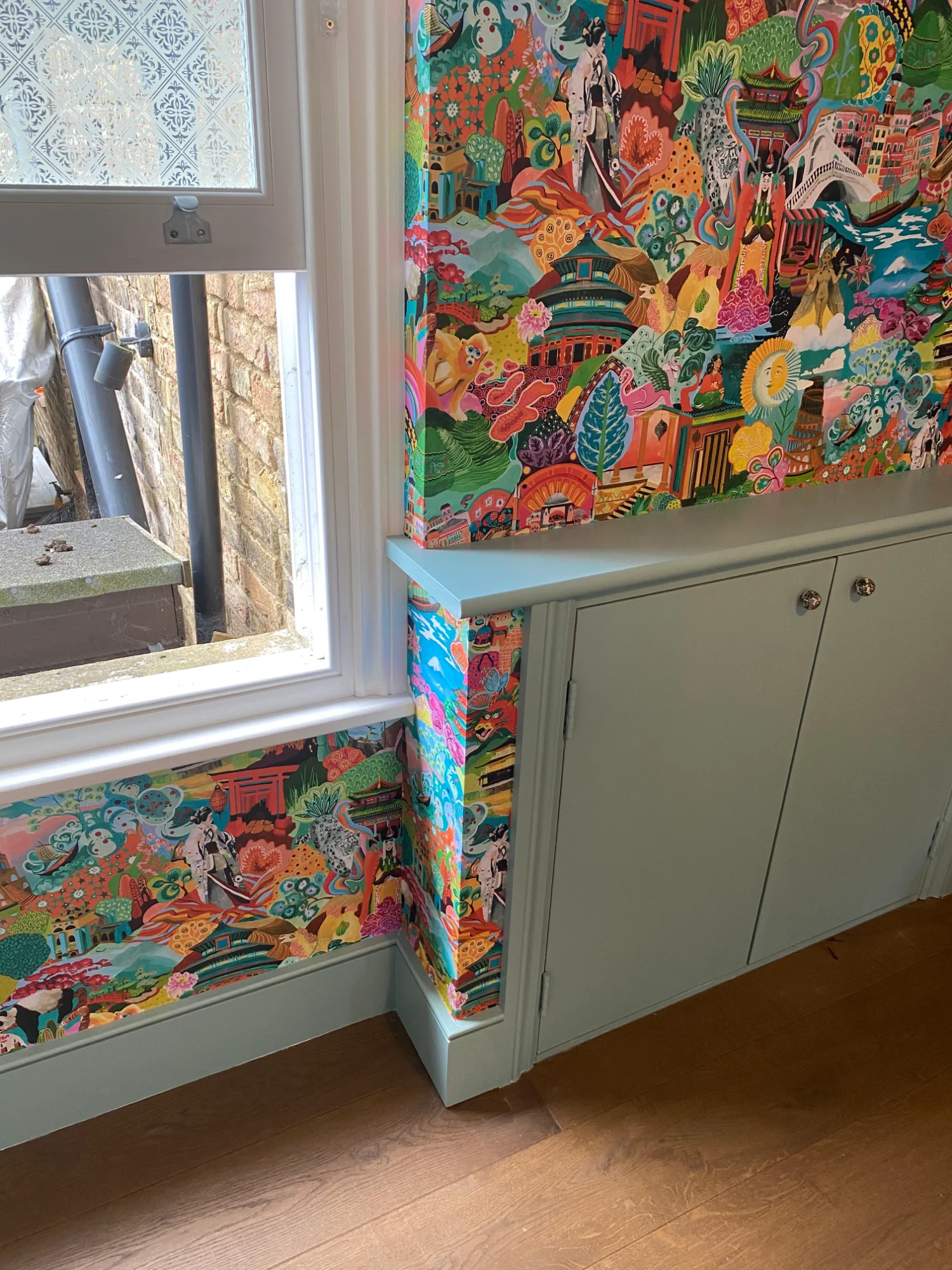 Intricate wallpaper installation around window recess