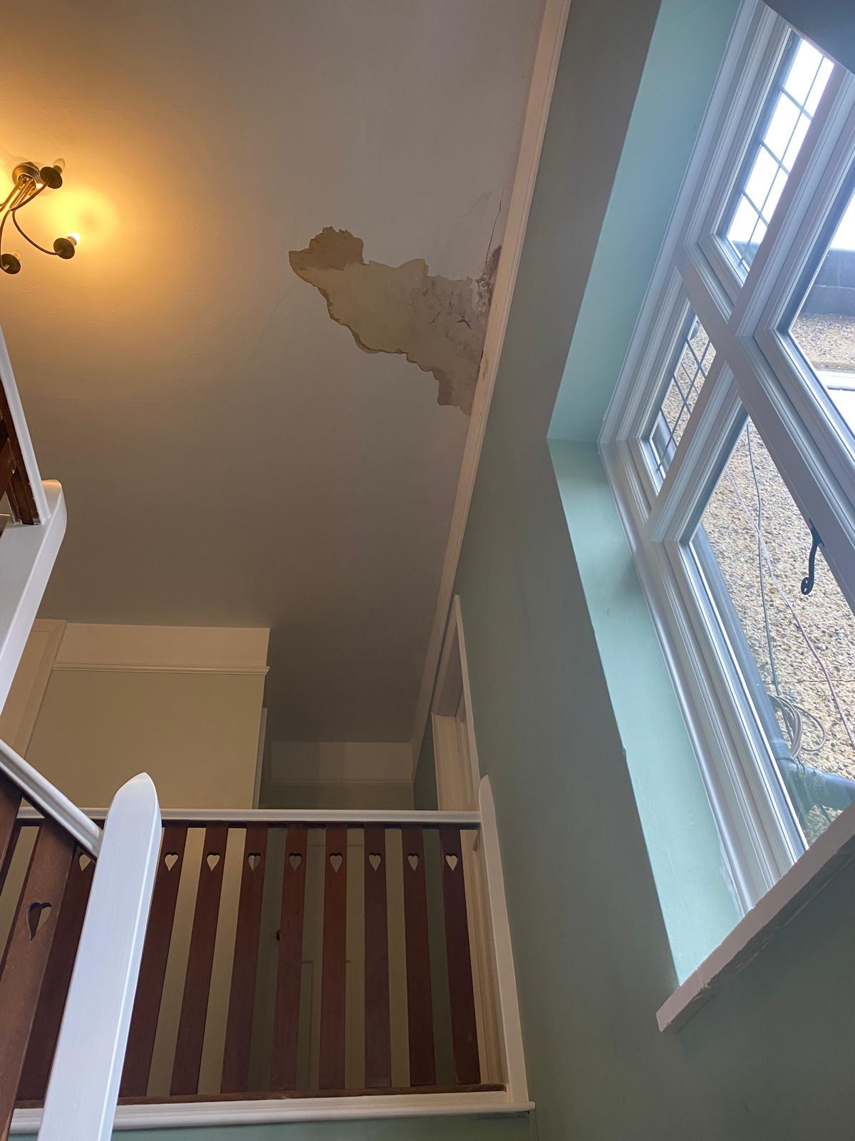 Cracked stairwell walls before repair and painting