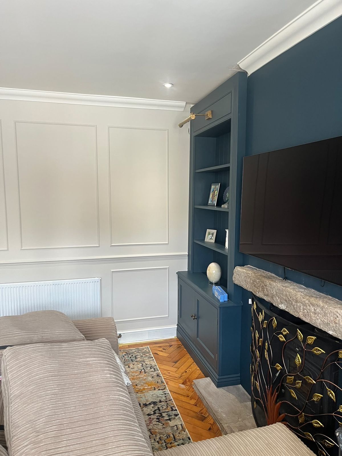 Living room in Rayleigh after repainting, with light panelled walls and navy alcove shelving